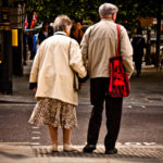 An elderly couple crosses the street hand in hand. Photo by garryknight.